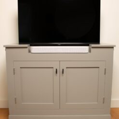 Vooraanzicht van de TV-kast met soundbar. TV met lift